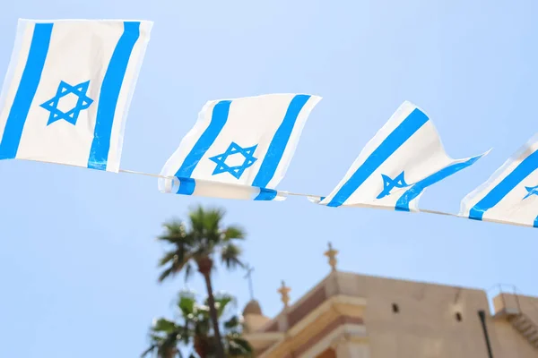 stock image Flags of Israel hanging on city street, closeup