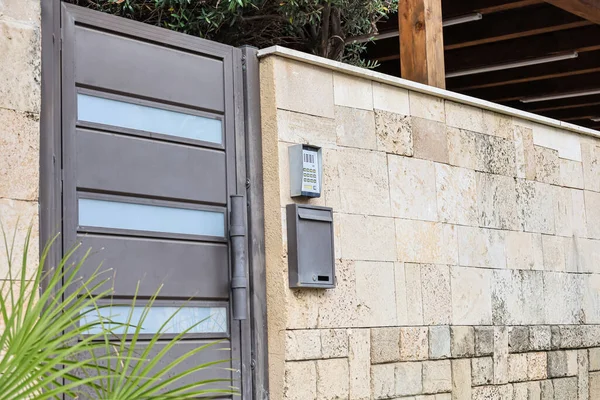 stock image View of fence with metal door, intercom and mailbox