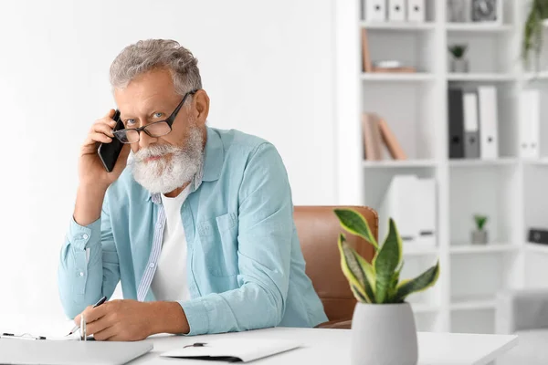 Senior Man Talking Mobile Phone Writing Table Office — Stock Photo, Image