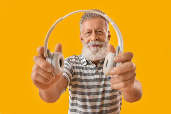 Starszy Brodaty Mężczyzna Słuchawkami Żółtym Tle — Zdjęcie stockowe