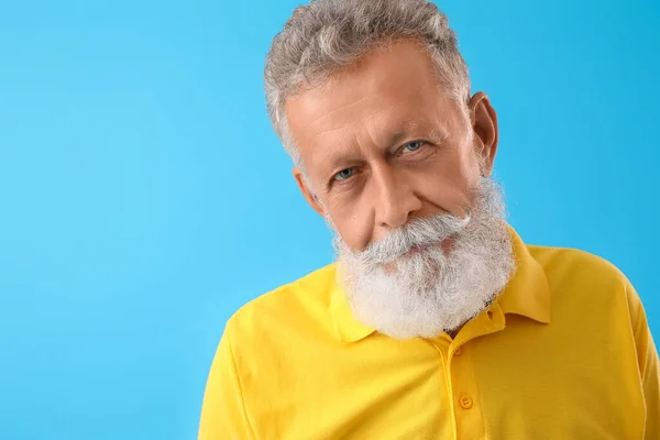 Pria Berjanggut Senior Dengan Kemeja Kuning Dengan Latar Belakang Biru — Stok Foto