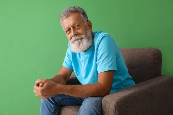 Uomo Anziano Seduto Poltrona Sfondo Verde — Foto Stock
