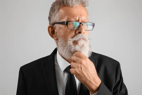 Tänksam Senior Man Glasögon Och Svart Kostym Grå Bakgrund Närbild — Stockfoto
