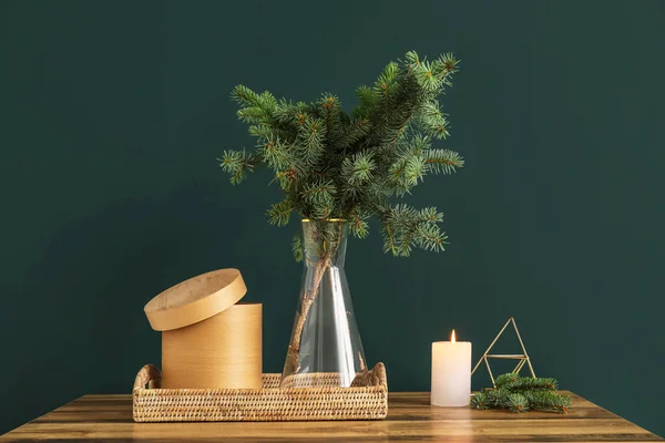緑の壁の近くのテーブルの上にクリスマスの枝 トレイ 燃えるろうそくと花瓶 — ストック写真