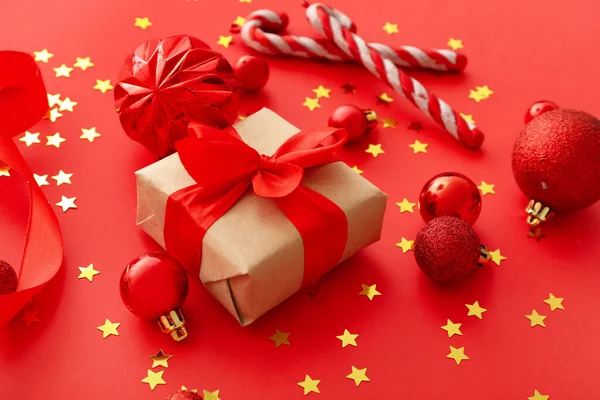 Komposition Mit Schöner Weihnachtsdekoration Und Geschenk Auf Rotem Hintergrund — Stockfoto