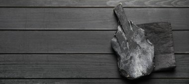 Koyu ahşap zemin üzerinde peçete ve metin için boşluk olan siyah kesme tahtası