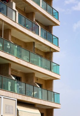 Gökyüzü arka planında balkonları olan bir binanın dış cephesi