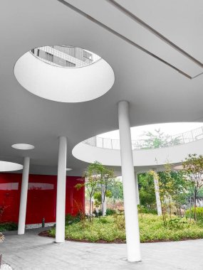 Büyük salonu ve bitkileri olan modern bir bina.