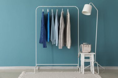 Mavi duvarın yanında örülmüş süveterler var.