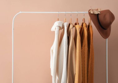 Örgü süveter ve bej duvarın yanında şapka.