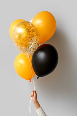 Işık duvarının yanında cadılar bayramı balonları olan kadın