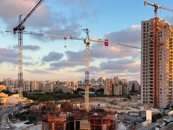 İnşaat alanları ve vinçleri olan şehir manzarası