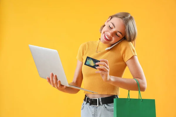 Kredi Kartı Dizüstü Bilgisayarı Olan Genç Bir Kadın Sarı Arka — Stok fotoğraf