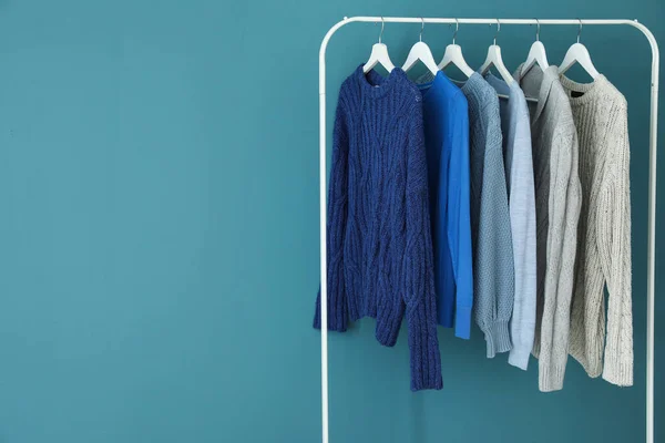 Rack Dengan Rajutan Sweater Dekat Dinding Biru — Stok Foto