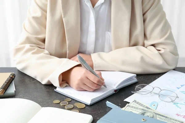 Uma Mulher Escrever Num Bloco Notas Mesa Perto Conceito Orçamental — Fotografia de Stock