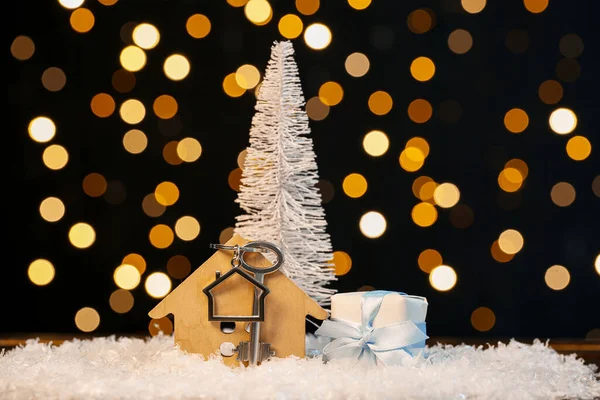 鍵付きの家の図 クリスマスツリーとぼやけた光に対する雪の贈り物 — ストック写真