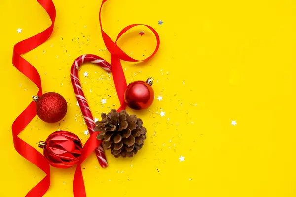 Composition Christmas Balls Candy Cane Pine Cone Ribbon Yellow Background — Stock Photo, Image
