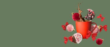 Noel süslemeleri ve yeşil arka planda zencefilli kurabiyelerle dolu lezzetli bir fincan sıcak çikolata.