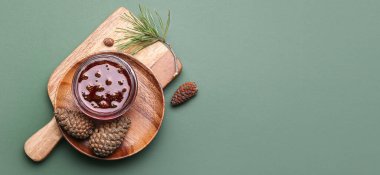 Yeşil zemin üzerinde bir kase lezzetli çam kozalağı ve metin için yeri olan bir tabak.