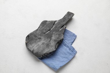 Beyaz zemin üzerinde peçete olan siyah tahta kesme tahtası.