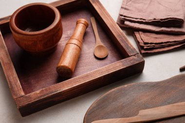 Beyaz arka planda peçeteleri olan ahşap mutfak malzemeleri.