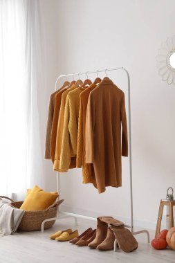 Kadın süveteri ve ayakkabılarıyla aydınlık odada dizilin.