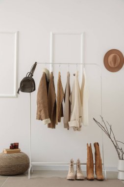 Kalın kadın kıyafetleri, çanta ve ayakkabıları ışıklı duvarın yanına dizin.