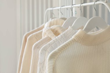 Süslü kadın kazakları askıda asılı, yakın plan.