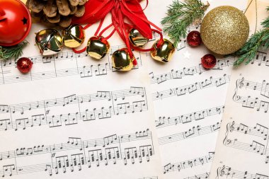 Noel dekoru, nota kağıtlarında çan ve kozalaklı dallar, yakın plan.