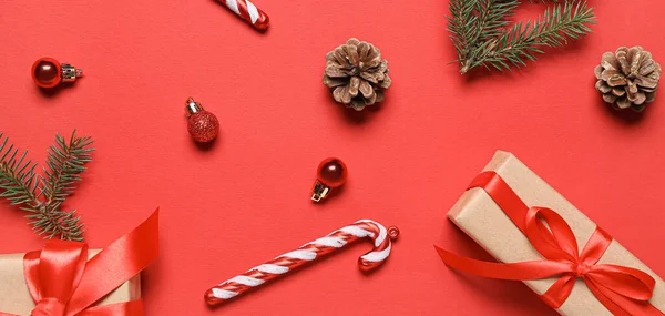 Weihnachtskomposition Mit Geschenken Dekorationen Und Nadelzapfen Auf Rotem Hintergrund — Stockfoto