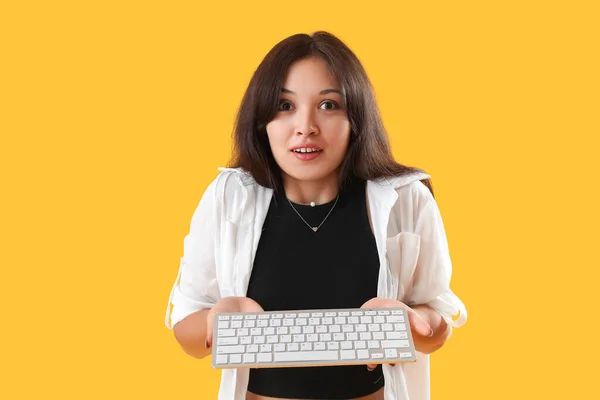 Verrast Jong Aziatisch Vrouw Met Computer Toetsenbord Gele Achtergrond — Stockfoto