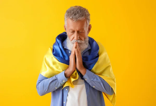 Reifer Mann Mit Fahne Der Ukraine Betet Auf Gelbem Hintergrund — Stockfoto