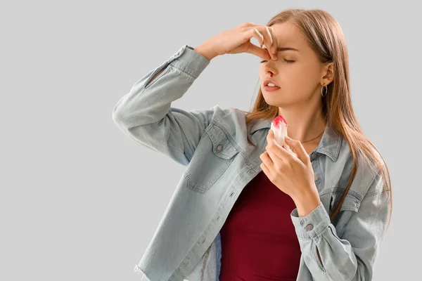 Mujer Joven Con Hemorragia Nasal Tejido Sobre Fondo Claro —  Fotos de Stock