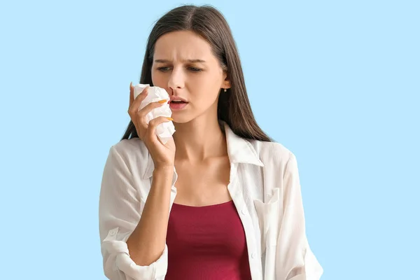 Junge Frau Mit Nasenbluten Und Gewebe Auf Blauem Hintergrund Nahaufnahme — Stockfoto