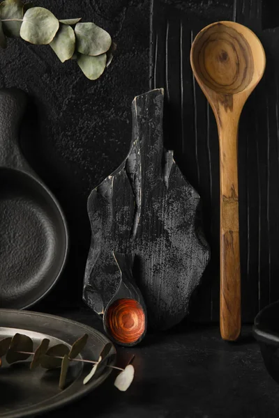 stock image Kitchen utensils with eucalyptus branches on black background