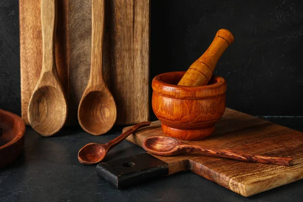木製のまな板 黒の背景に杵とスプーンでモルタル — ストック写真