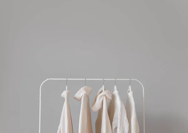 Stojak Stylowymi Kobiecymi Swetrami Przy Ścianie — Zdjęcie stockowe