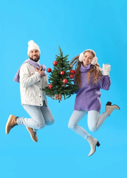 Junges Paar Mit Weihnachtsbaum Springt Auf Blauem Hintergrund — Stockfoto