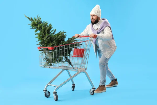 Όμορφος Άνθρωπος Καλάθι Αγορών Και Χριστουγεννιάτικο Δέντρο Μπλε Φόντο — Φωτογραφία Αρχείου