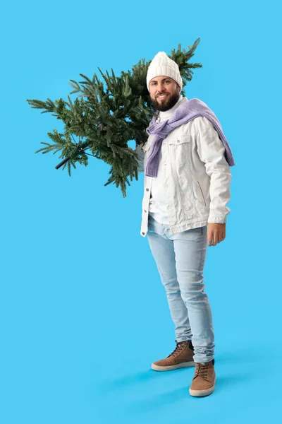 ハンサムな男とともにクリスマスツリー上の青の背景 — ストック写真