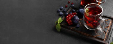 Koyu arkaplanda bir bardak meyve çayı ve metin için boşluk