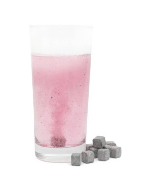 Beyaz arkaplanda çözünür tabletlerle bir bardak su.