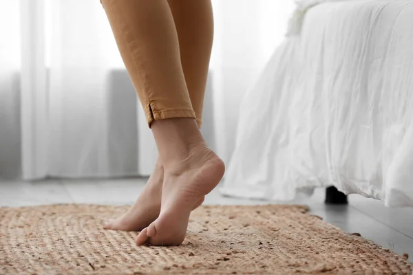 女性裸足足オンウィッカーカーペットでベッドルーム — ストック写真