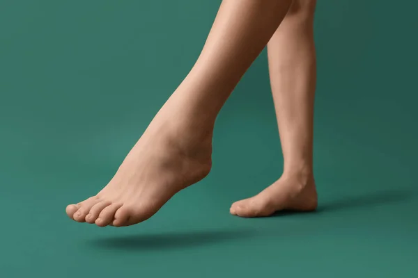 緑の背景に女性の裸足の足 — ストック写真