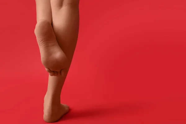 赤い背景の女性の裸の足は — ストック写真