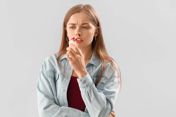 Mujer Joven Con Hemorragia Nasal Tejido Sobre Fondo Claro —  Fotos de Stock