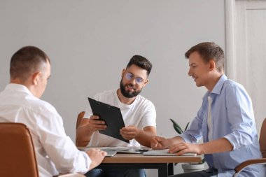 Ofisteki meslektaşlarıyla çalışan yakışıklı bir banka müdürü.