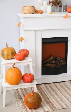 Cadılar Bayramı balkabakları ve şömine ışıklı duvarın yanında.