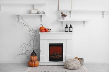 Cadılar Bayramı balkabaklarıyla beyaz şömine ve aydınlık oturma odasında fenerler.