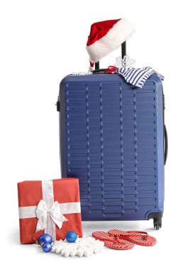 Noel Baba şapkalı çanta, Noel hediyeleri ve beyaz arka planda seyahat aksesuarları.